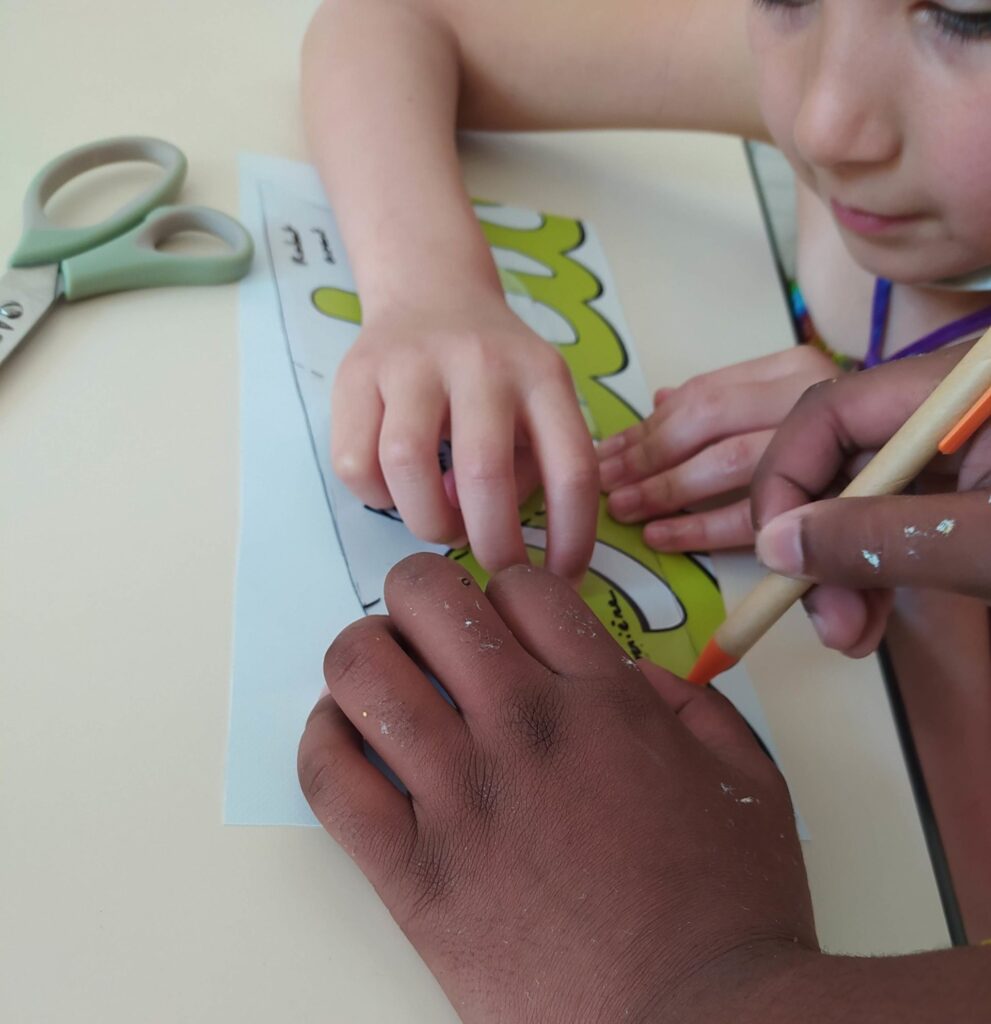 Enfants en train de tracer une forme à l'aide d'un patron