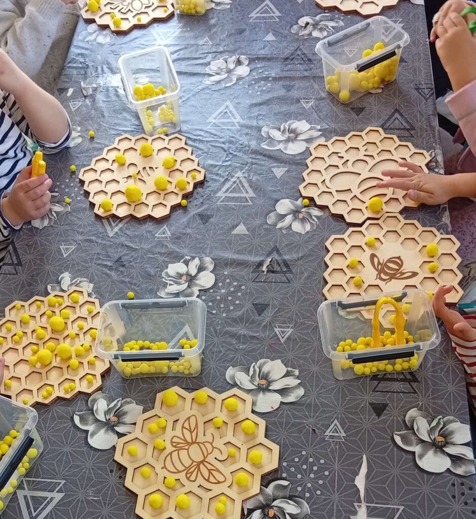 Jeu de motricité fine avec des grains de pollen à disposer dans des alvéoles à l'aide de pinces
